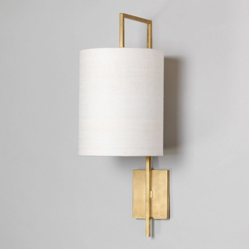 Vegglampe i messing med hvit sylinderformet lampeskjerm i lin