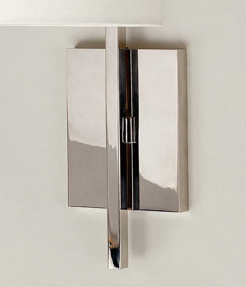 Detaljbilde av vegglampe i nikkebelagt messing med hvit sylinderformet lampeskjerm i lin